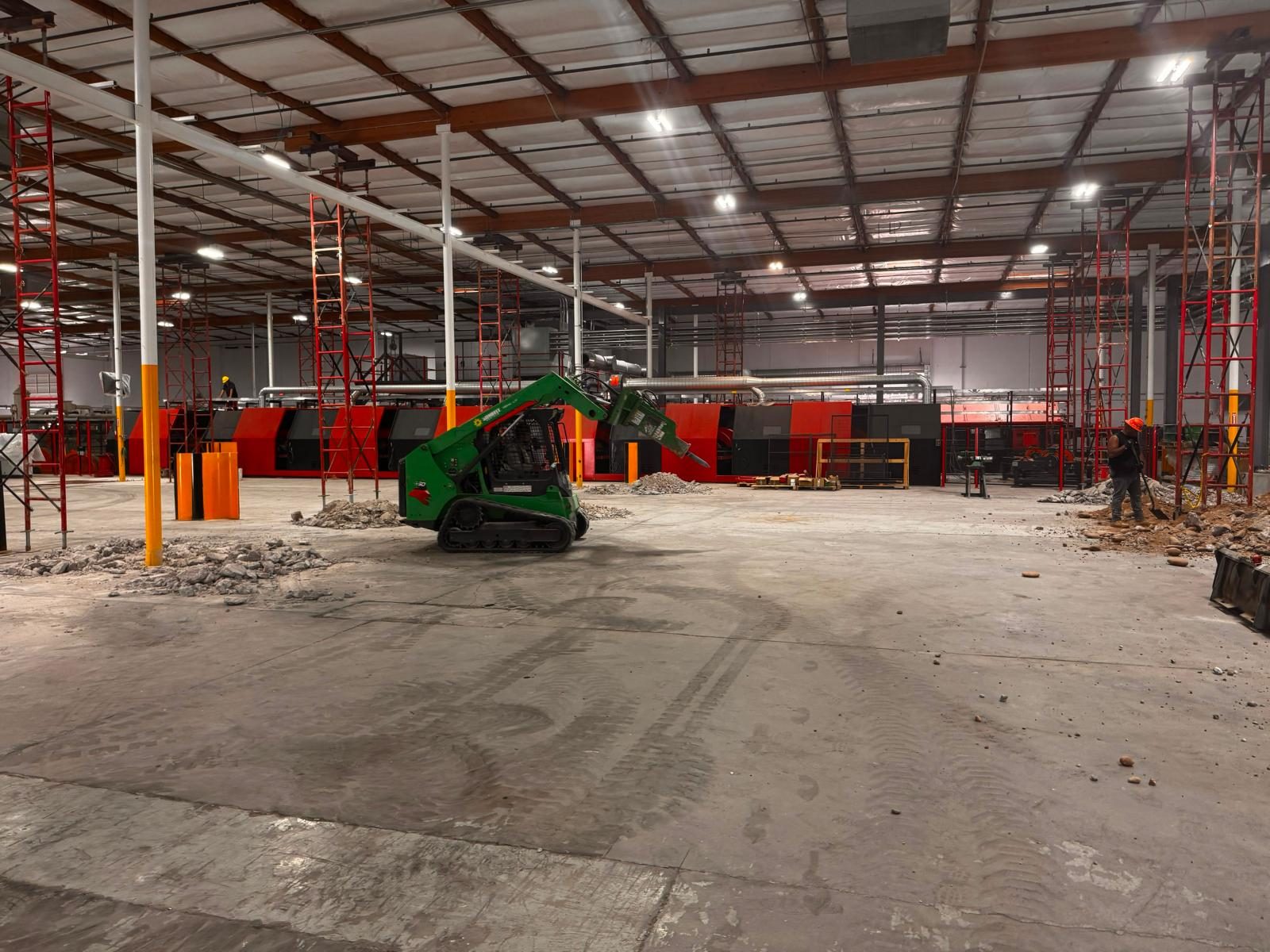 Breaking out the slab with a skid-steer hammer ahead of new equipment pads