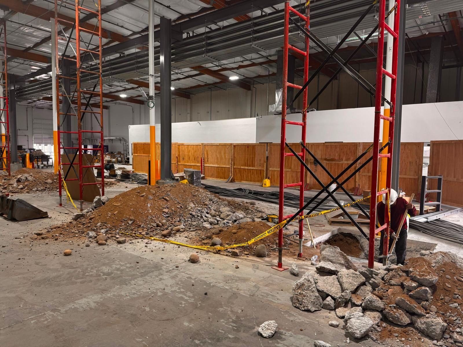 Excavation between scaffold towers, with the area taped off