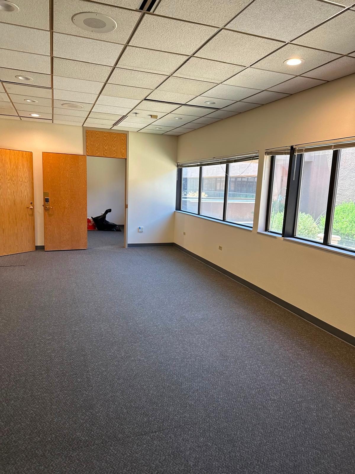 Office with new carpet tile, fresh paint and base along the window wall