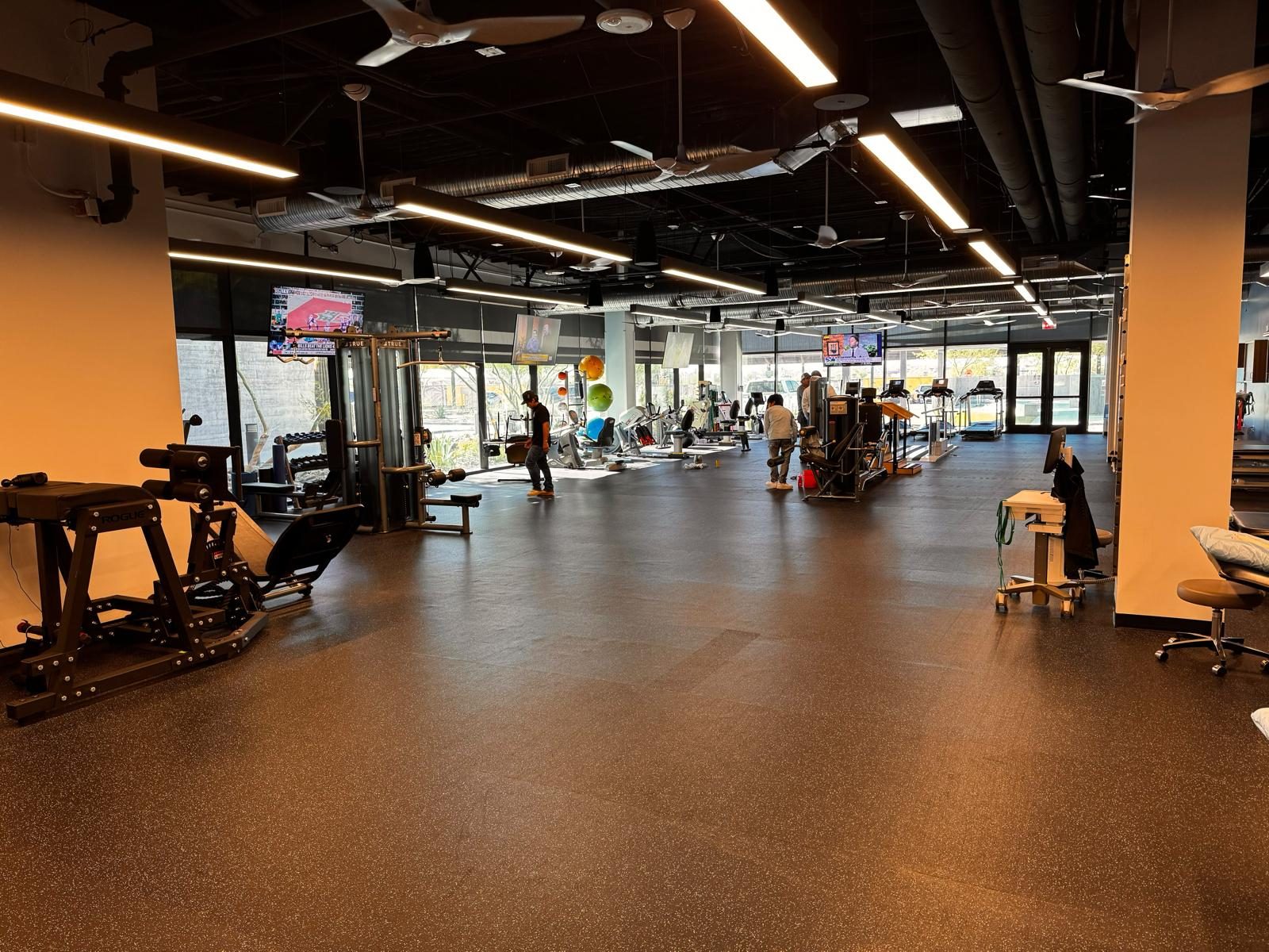 Therapy floor in use, with cable machines along the glazing
