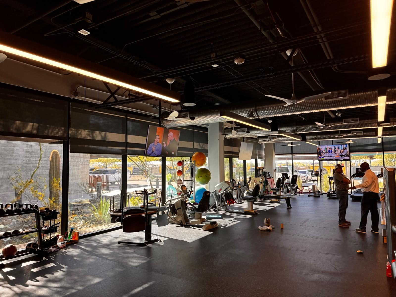 Cardio and rehab equipment along full-height glazing onto desert landscaping